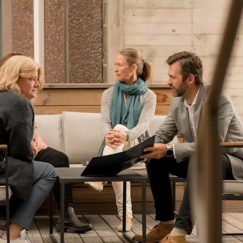 Begravelsesrådgiver i samtale med pårørende i rolige omgivelser.